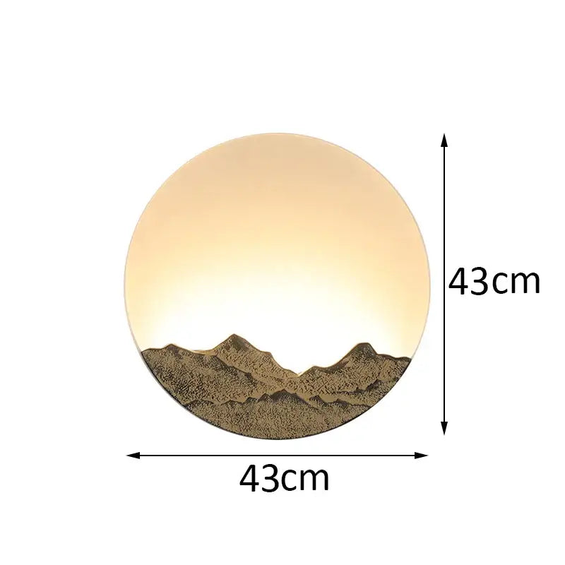Circular wall light with warm amber glow and textured bronze chinese mountain silhouette by decorbites led wall light