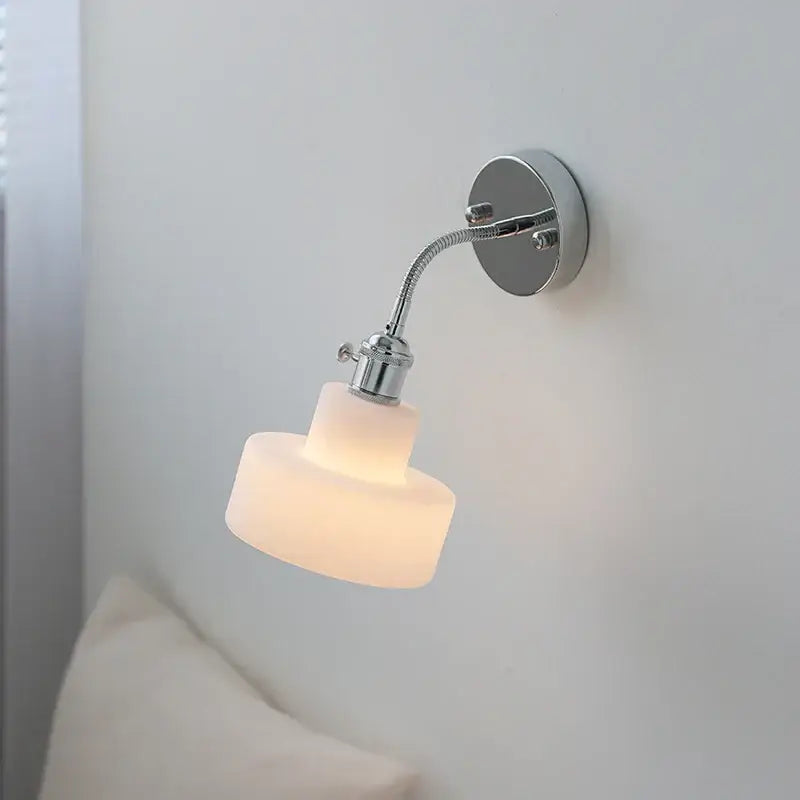 A sleek chrome adjustable arm wall lamp with ribbed glass shade emitting warm light for bedroom decorbites adjustable arm