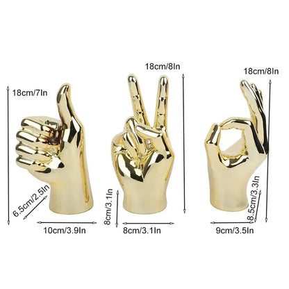 Set of three golden metallic love gesture figurines with thumbs up peace and ok signs for living room decor