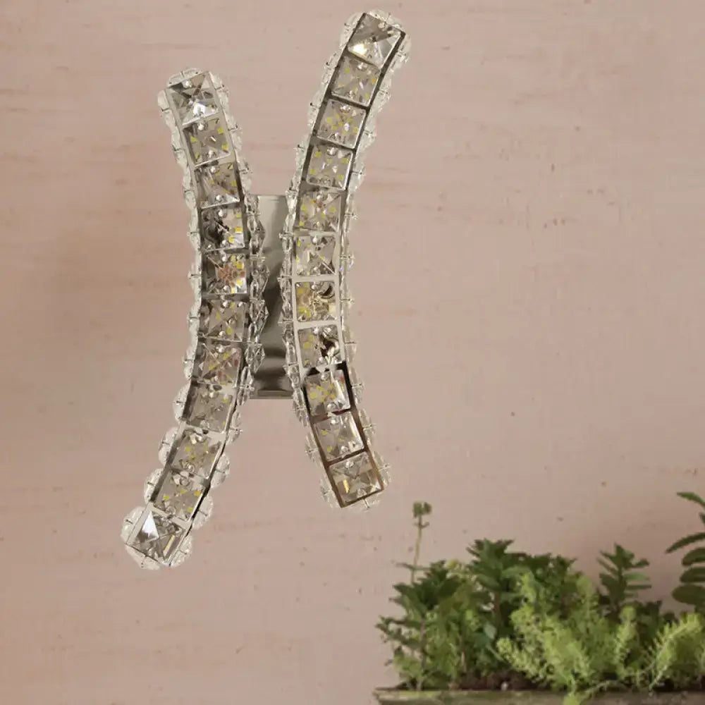 Chrome curvy wall sconce in silver with crystal prism accents shaped like the letter h for living room decor
