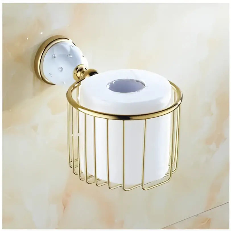 Gold-toned metal toilet paper holder with cylindrical wire cage and circular plate in chrome and gold ceramic bathroom hardware set