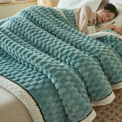 A mint-green coral fleece blanket with raised texture and cream trim, perfect as a chunky knit bedroom throw