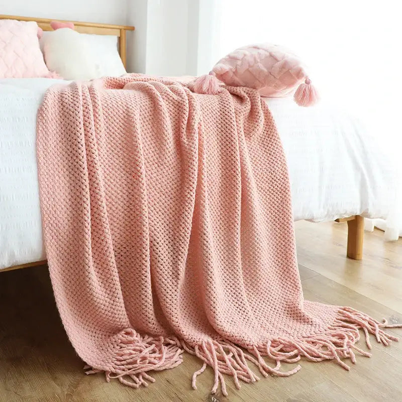 A soft pink decorbites knitted leisure blanket with textured diamond pattern and tassels for bedroom and living room decor
