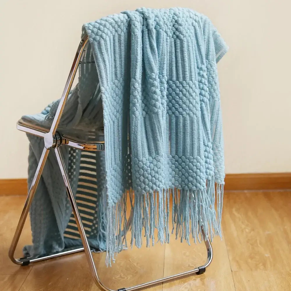 A soft light blue cozy knitted sofa blanket with a textured pattern and fringe for living room decorbites cozy knitted comfort