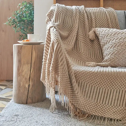 Beige chunky ribbed knitted sofa blanket with textured macrame pattern and fringe for decorbites cozy knitted decor