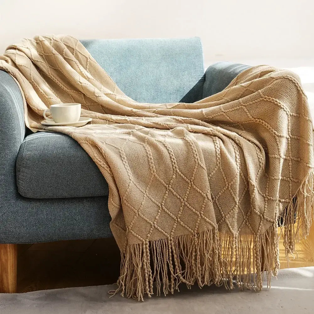 Beige cozy knitted sofa blanket with diamond pattern and fringe for living room comfort by decorbites cozy knitted