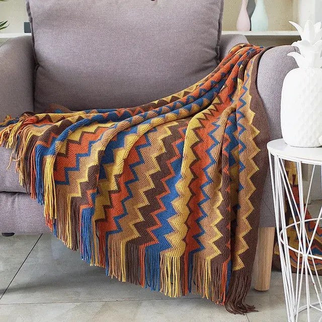 Classic black and white houndstooth throw blanket with fringe draped over gray armchair by decorbites houndstooth throw