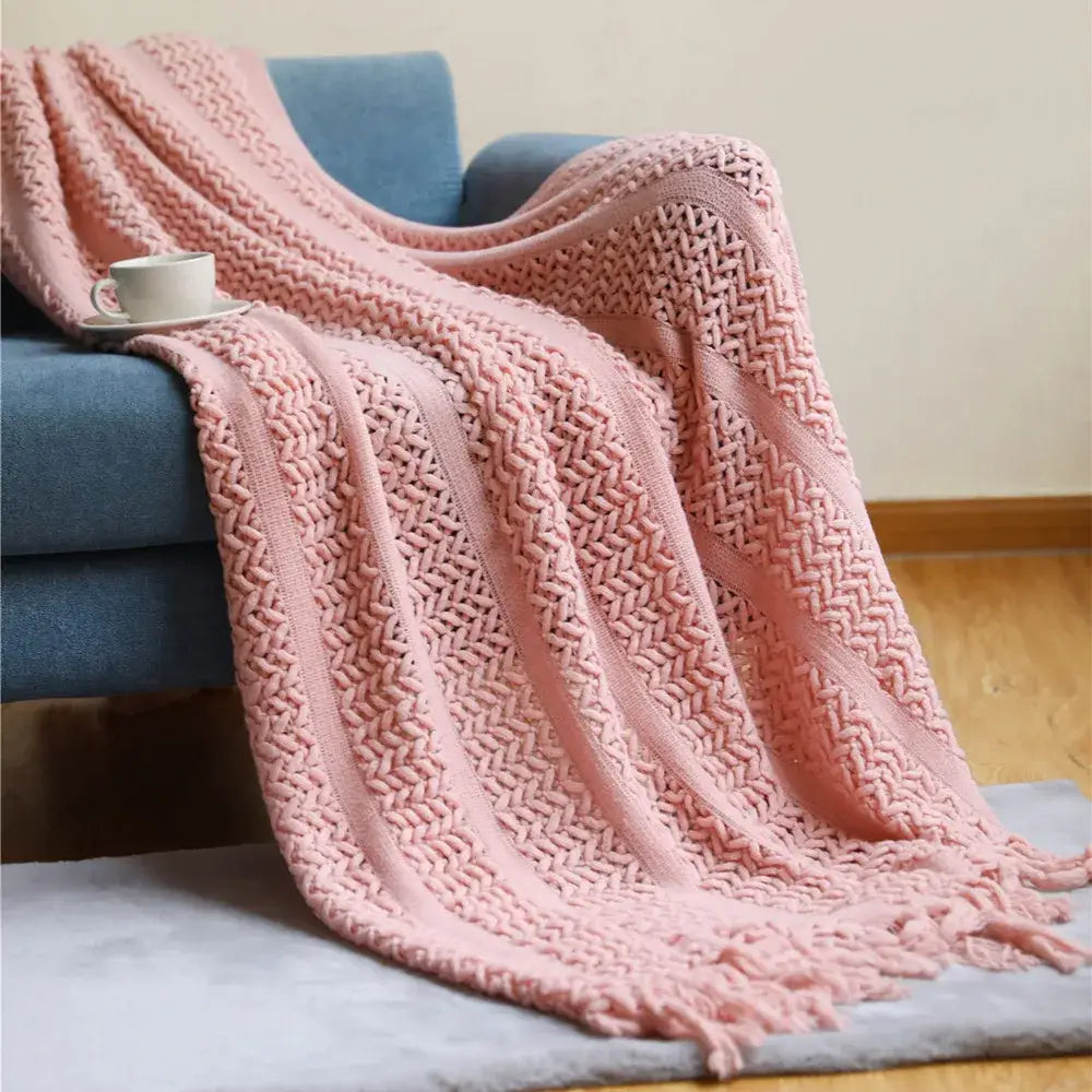 A soft pink knitted throw blanket with herringbone pattern and fringed edges for decorbites houndstooth throw collection