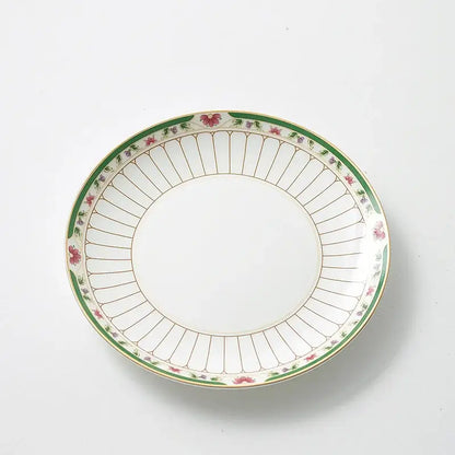 White ceramic plate with green border and floral motifs paired with classical gold-striped ceramic cup and saucer set