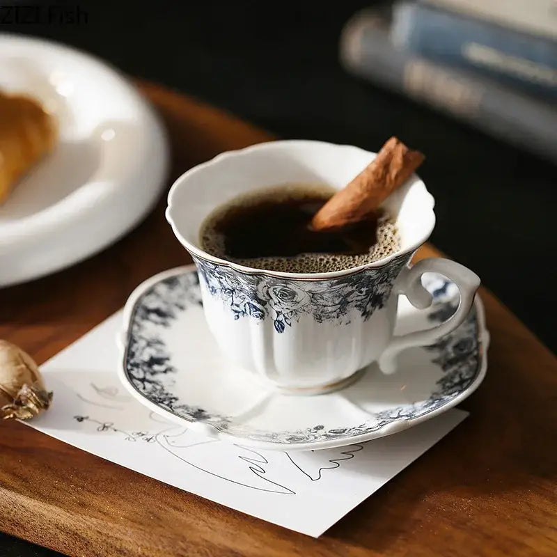 White porcelain ceramic cup and saucer set with delicate black floral patterns in a classical grey blue rose design