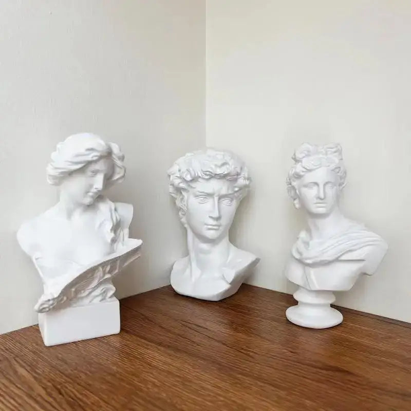 Three white marble-style classical david statue head sculptures with distinct hairstyles and draped garments for mini decor
