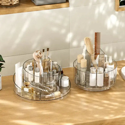 Clear two-tier rotating acrylic makeup organizer with segmented compartments for bedroom vanity storage