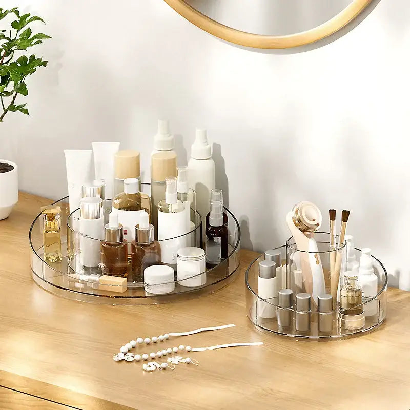 Clear two-tiered rotating acrylic makeup organizer with circular design and transparent compartments for vanity storage