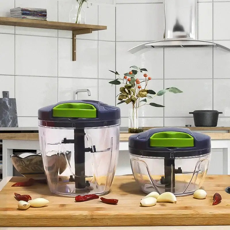 Two transparent plastic mini food shredders with navy blue and lime green lids for kitchen garlic prep on wood countertop