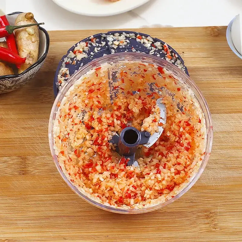 Clear 400ml plastic mini food shredder bowl filled with finely chopped red chili and garlic for kitchen prep