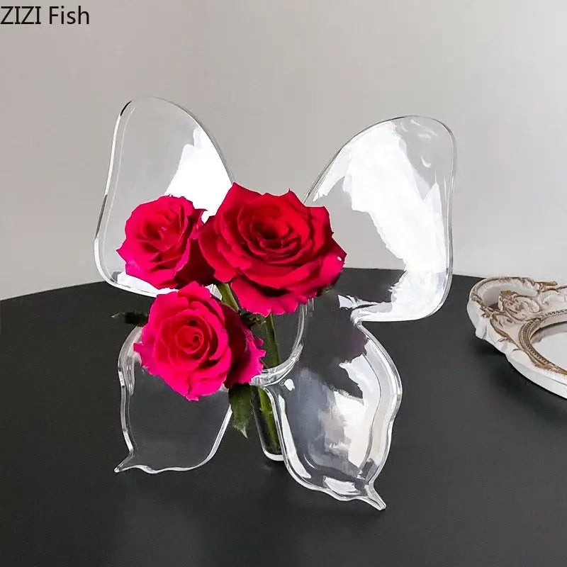 Clear acrylic butterfly vase by decorbites holding three vibrant red roses for bedroom flower arrangement decor