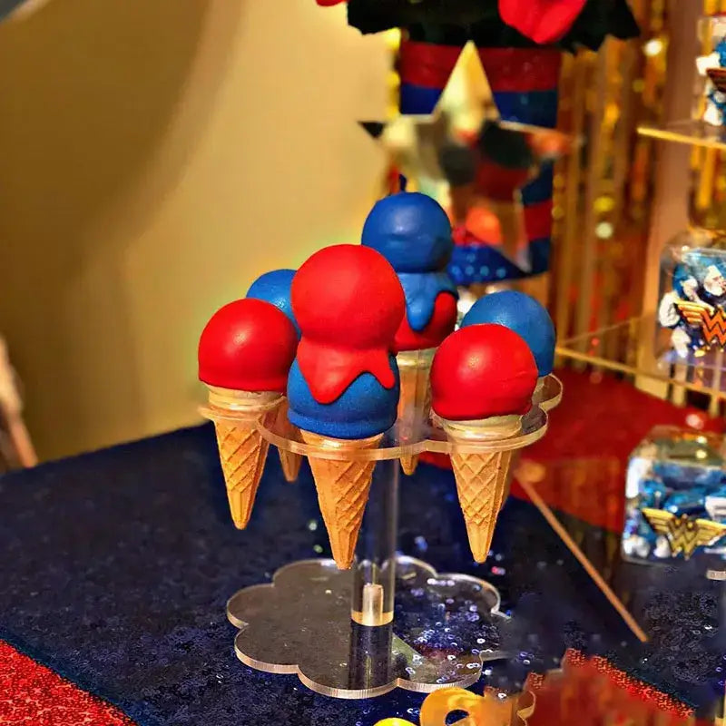 Clear acrylic cone holder stand displaying red and blue ice cream cone cake pops for kitchen display rack