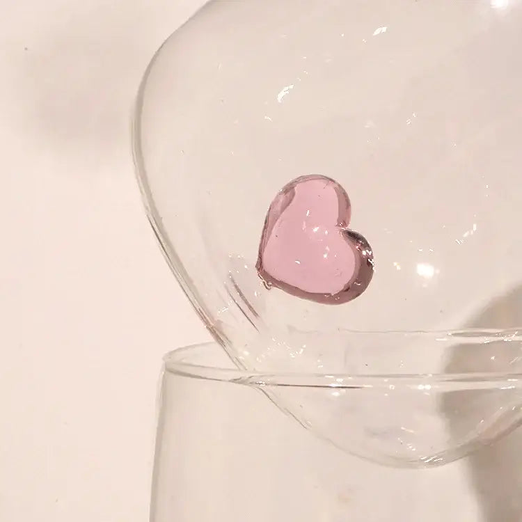 A translucent pink glass heart ornament inside a clear bowl complementing a clear and blue heart tumbler mug decorbites 3d heart
