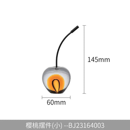 Clear and gold crystal cherry sculpture with a vibrant orange yellow interior and black stem for living room decorbites decor