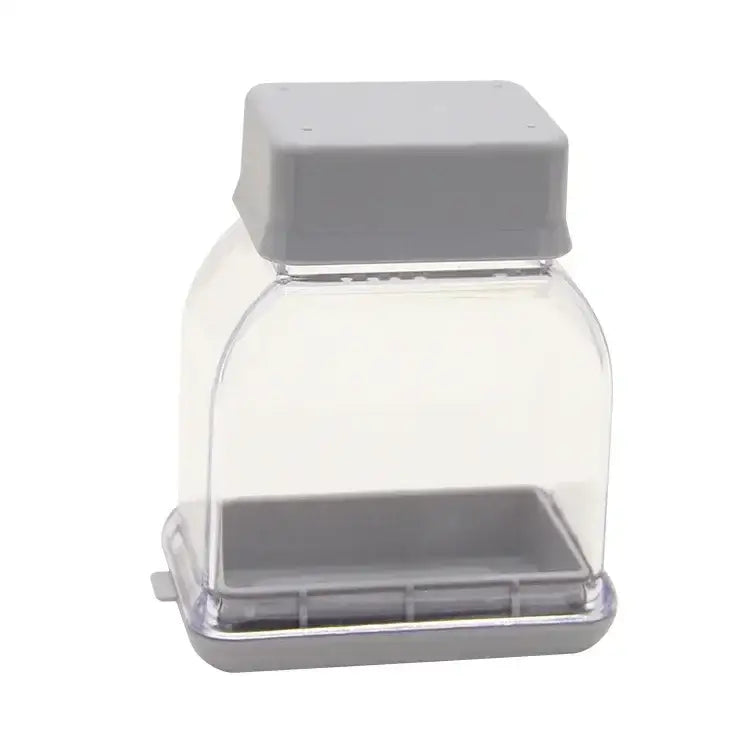 Clear plastic bird feeder with gray lid and base shown alongside decorbites garlic grinding grater cutter kitchen tool