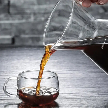 Clear glass coffee pot with stainless steel filter pouring dark espresso into matching glass mug with 400ml mark