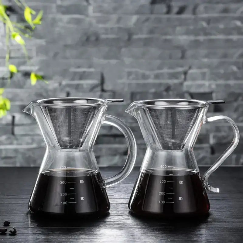 Two clear glass coffee pots with stainless steel filter and measurement markings filled with dark brewed coffee