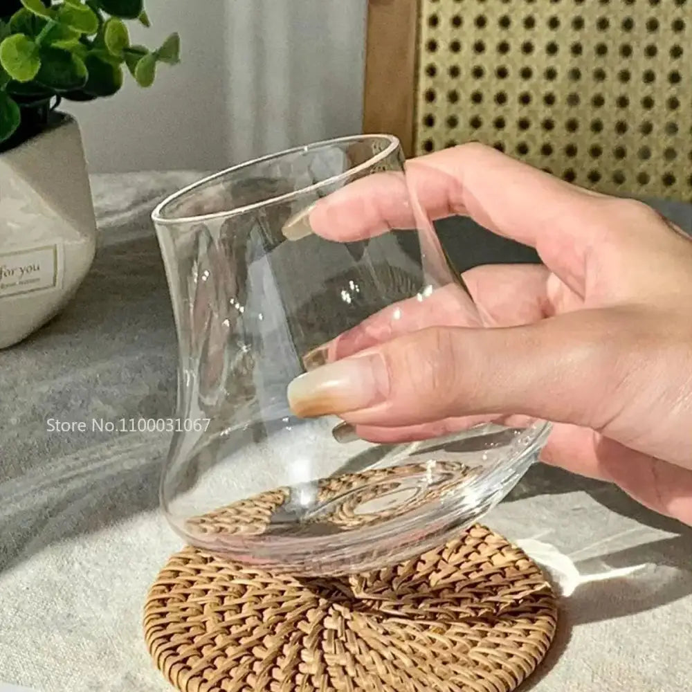 Clear glass tumbler with curved modern design and smooth edges in cold brew latte drinkware set with wooden coaster