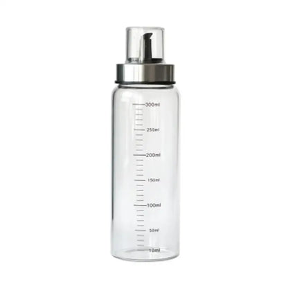 Clear glass condiment bottle with silver pump dispenser and milliliter measurements in glass condiment bottle set for kitchen use