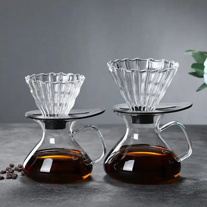 Clear glass drip pot coffee set with fluted glass drippers and black bases atop glass carafes filled with brewed coffee