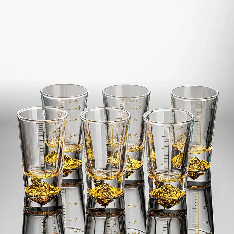 Clear glass liquor cup set with gold measurement markings and golden liquid for decorbites clear glass dining room decor