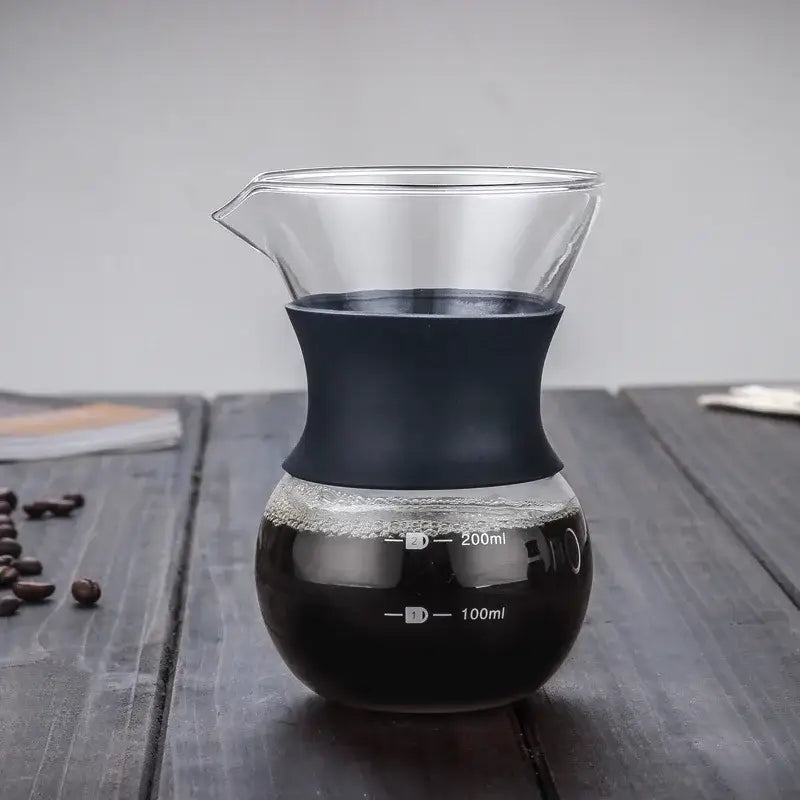 Clear glass pour over coffee maker with stainless steel filter and matte black silicone handle with measurement markings