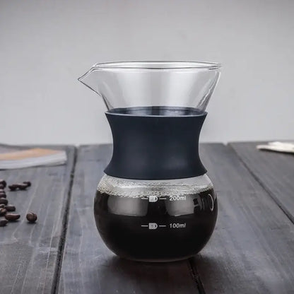 Clear glass pour over coffee maker with stainless steel filter and matte black silicone handle with measurement markings