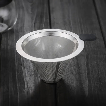A sleek stainless steel filter tea infuser with black handle designed for use with clear glass pour over coffee maker
