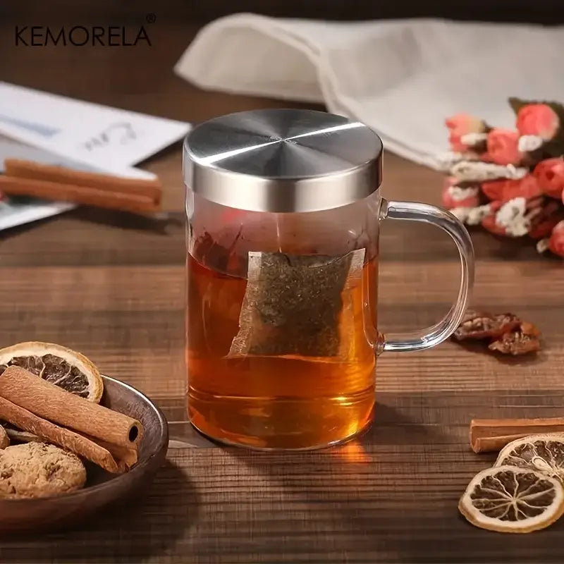 Clear glass tea infuser mug with stainless steel infuser lid and handle steeping tea in amber liquid