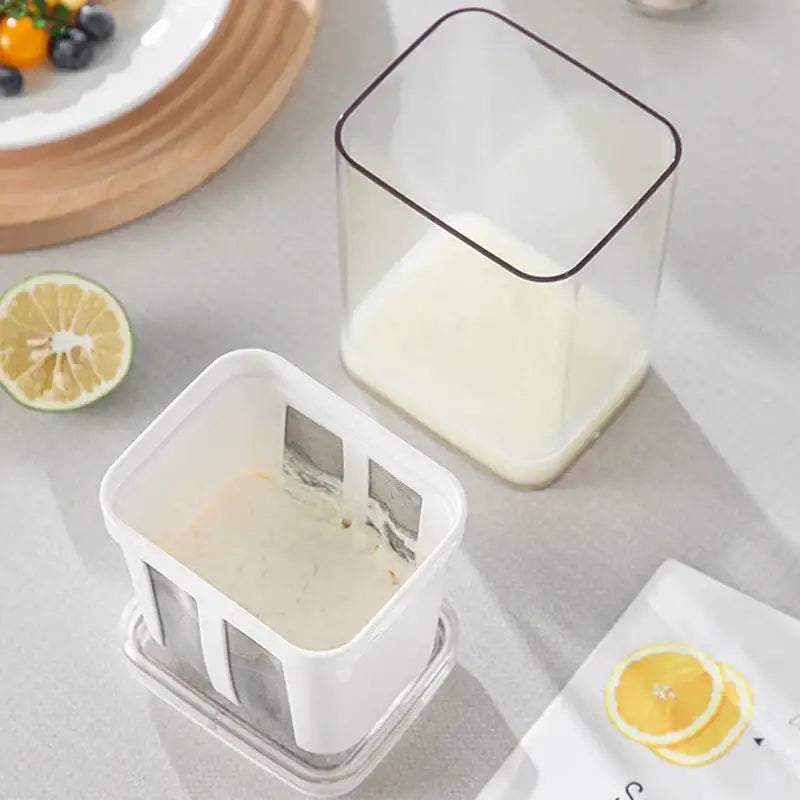 Clear plastic greek yogurt maker container with white interior black rim and white lid mesh filter for homemade yogurt