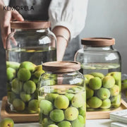 Clear kitchen glass jars set of 2 with acacia lids containing green plums in liquid for food storage