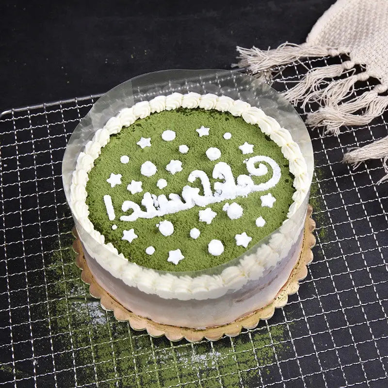 A round matcha green cake with white frosting border and decorbites cake edge wrap for mousse decorating