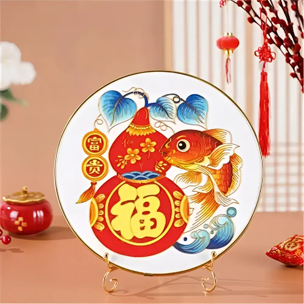 A round white ceramic plate with gold rim featuring vibrant cloisonne silk enamel diy kit red and blue decorbites design
