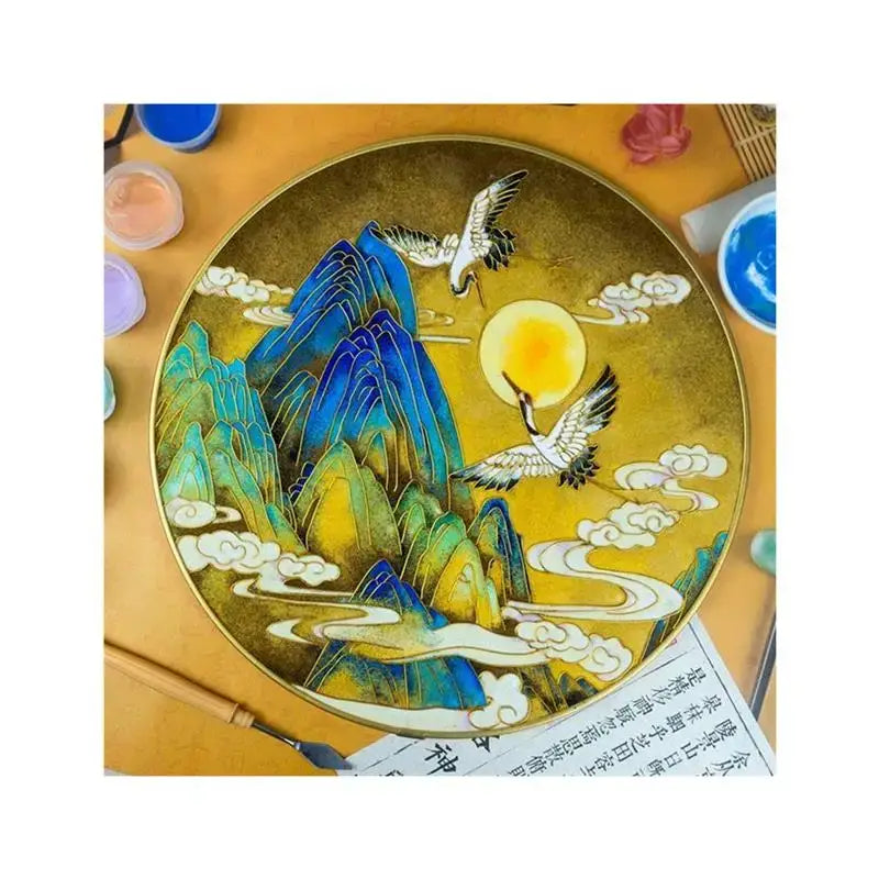 A circular gold-toned cloisonne silk enamel painting diy kit featuring blue and green mountains with cranes and sun decorbites cloisonne silk