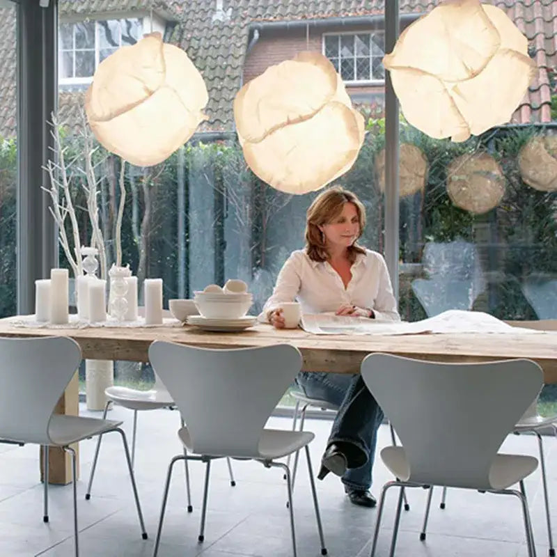 Three large cream-colored rice paper pendant lights hang as a decorbites cloud white pendant cluster for kitchen decor
