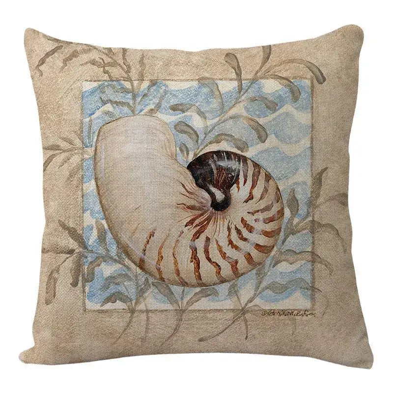 Beige linen decorbites coastal cushion featuring a nautilus shell illustration with blue waves and gray-green foliage