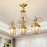 Brass-finished DecorBites™ colonial lantern island light fixture with three ornate ivory glass lanterns for dining room