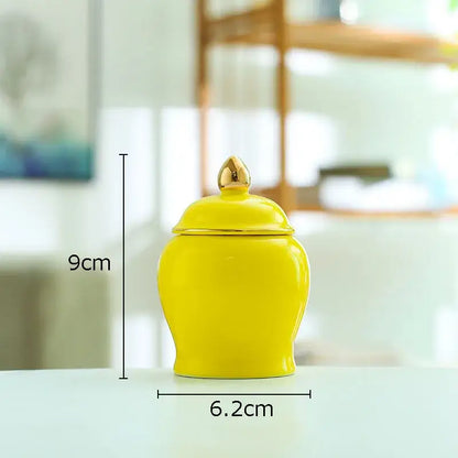 Bright yellow ceramic storage jar with matching lid and gold-toned finial ideal for kitchen tea caddy use