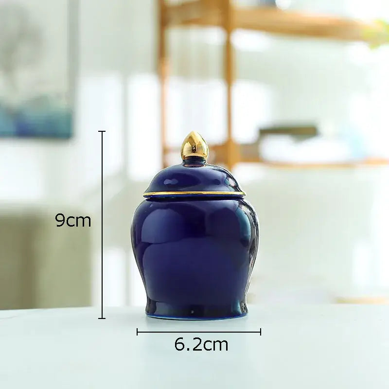 Deep blue ceramic storage jar with gold-toned lid and decorative finial for kitchen tea caddy use