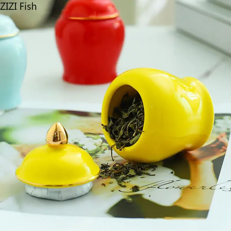 Vibrant yellow ceramic storage jar with gold-tipped lid in an elegant rounded shape for kitchen tea caddy use