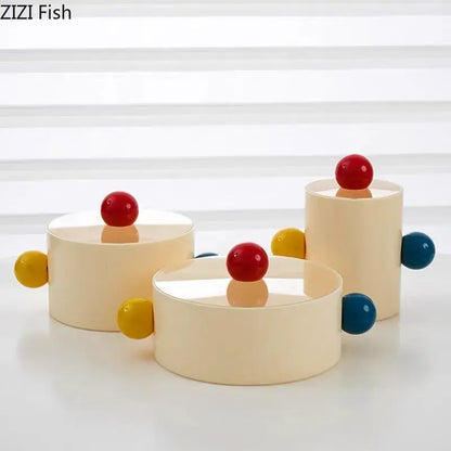 Cream-colored cylindrical storage jar with colorful dot decorative glossy red yellow and blue spheres for bedroom organization
