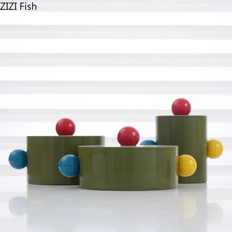 Olive-green cylindrical ceramic storage jar with colorful dot decorative red blue and yellow accents for bedroom organizer