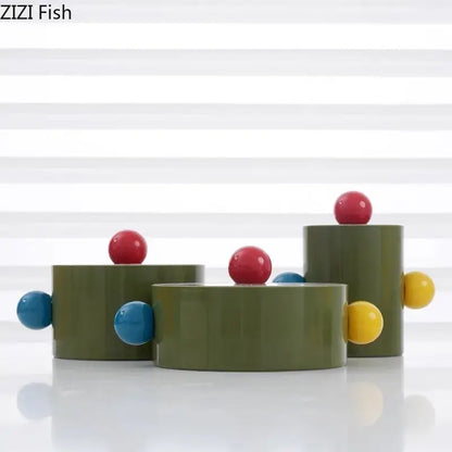 Olive-green cylindrical ceramic storage jar with colorful dot decorative red blue and yellow accents for bedroom organizer