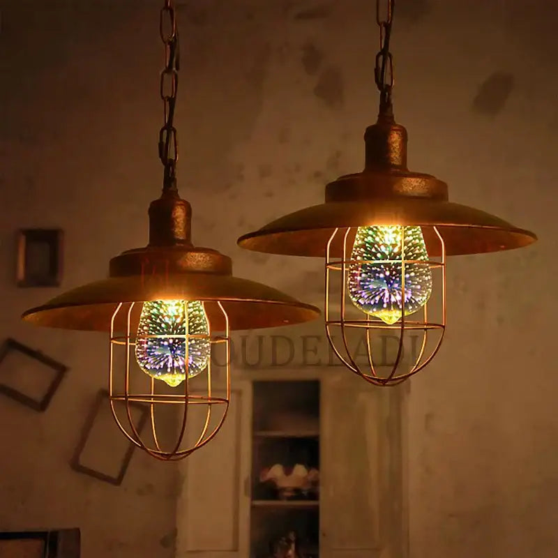 Two rustic brass pendant lights with cage fixtures and colorful filament bulbs complement decorbites colorful fireworks table lamp