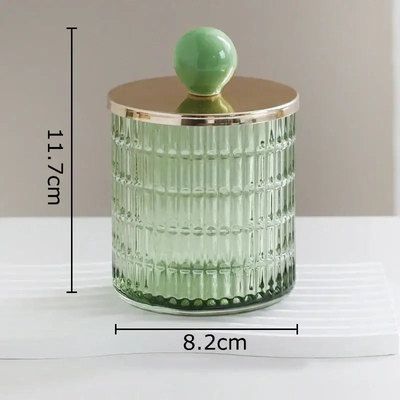 A translucent green decorbites glass tea canister with vertical ridges and a gold-toned lid storage jar